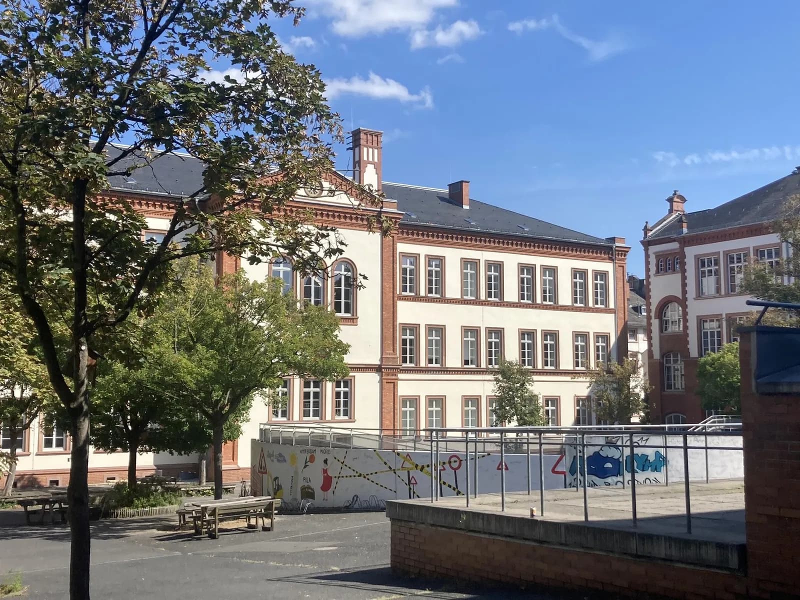 Der alte Schulhof der Oranienschule mit Asphalt und einer mit Graffiti besprühten Mauer
